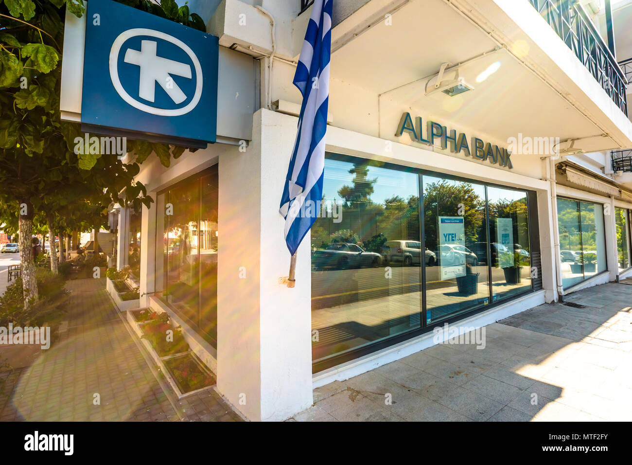 Città di Olimpia, Peloponneso e Grecia - Agosto 19, 2015: banca greca finestra con ATM e Bandiera della Grecia del locale Alpha Bank Foto Stock