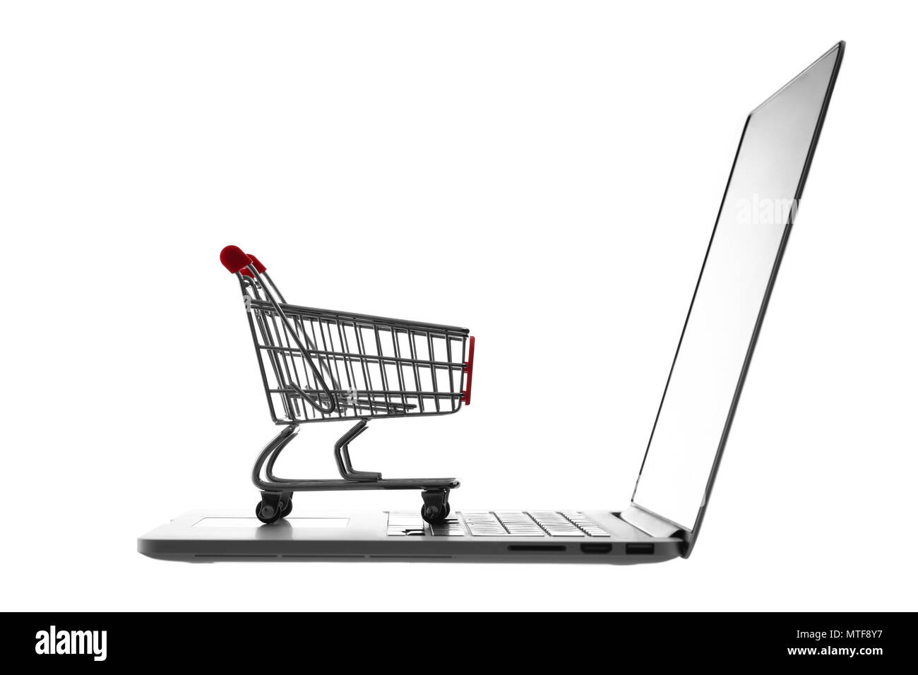 Carrello spesa su computer portatile isolato su sfondo bianco. L'E-commerce, la concezione di business. Foto Stock