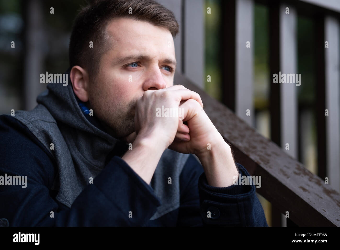 Triste uomo caucasico seduto da solo e thinling circa i problemi. Foto Stock