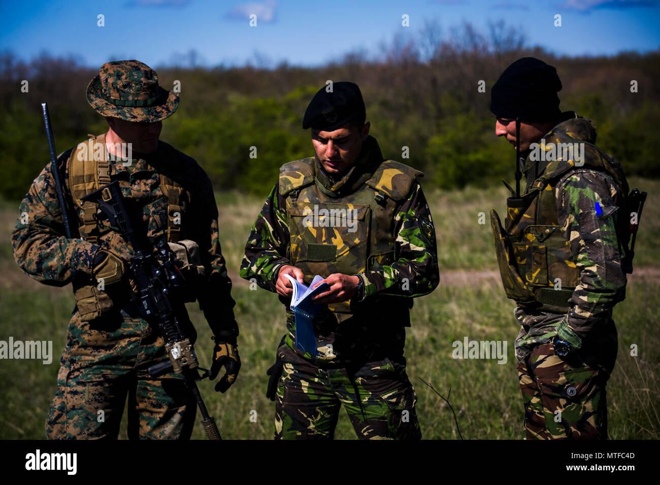 Stati Uniti Marine 1Lt. Sean Gil, un comandante di plotone con Marine forza rotazionale Europa 17.1, parla con soldati rumeni a Babadag Area Formazione, Romania, 24 aprile 2017. Marines addestrati con i rumeni durante l'esercizio Platinum Eagle 17.2 per migliorare le competenze e l'interoperabilità. Gli Stati Uniti e l Europa deve preservare un reciproco impegno e fiducia come essi affrontare sempre nuove sfide insieme. Foto Stock