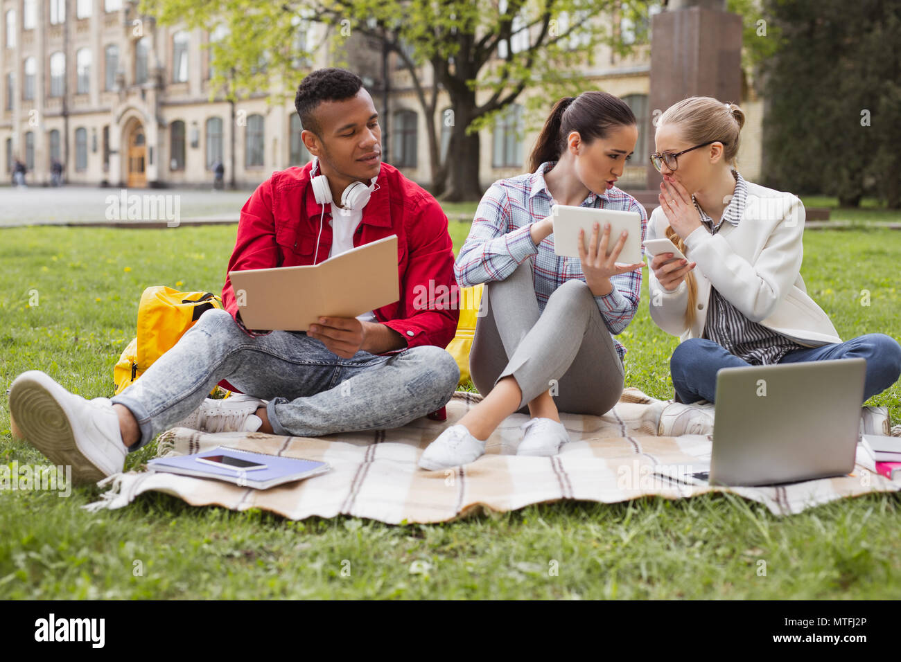 Tre studenti discutendo attuali eventi mondiali Foto Stock