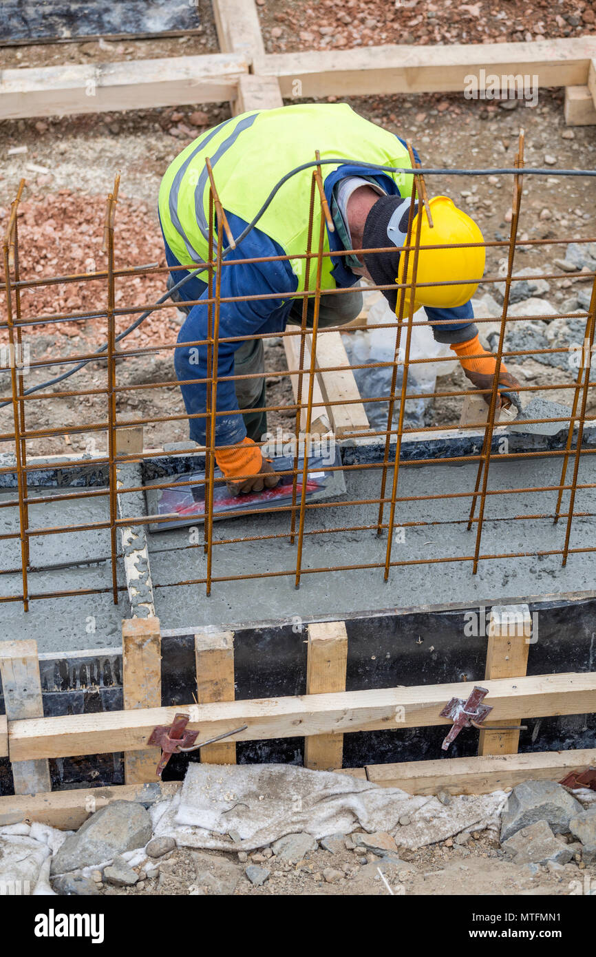 Livellamento del basamento in cemento pour con tondino e cassero. Foto Stock