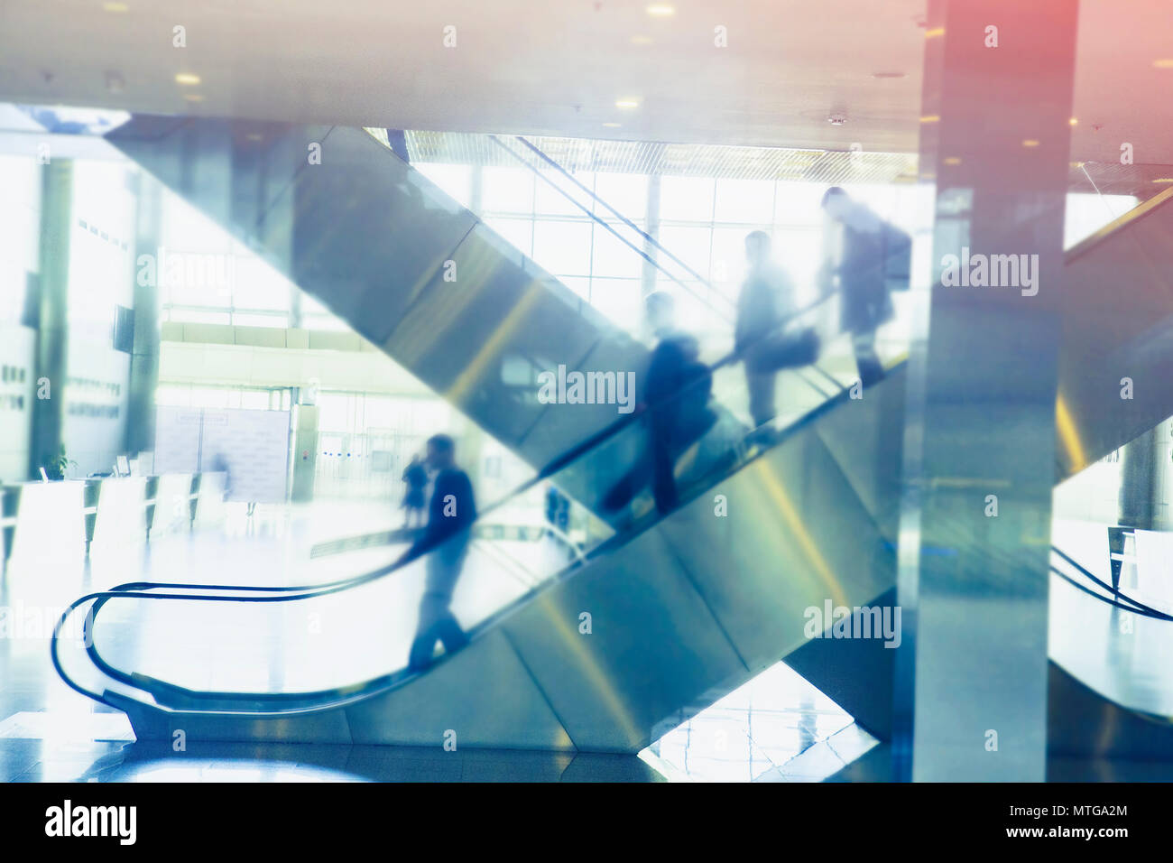 Foto sfocata di scale mobili in edificio moderno nei toni del background Foto Stock