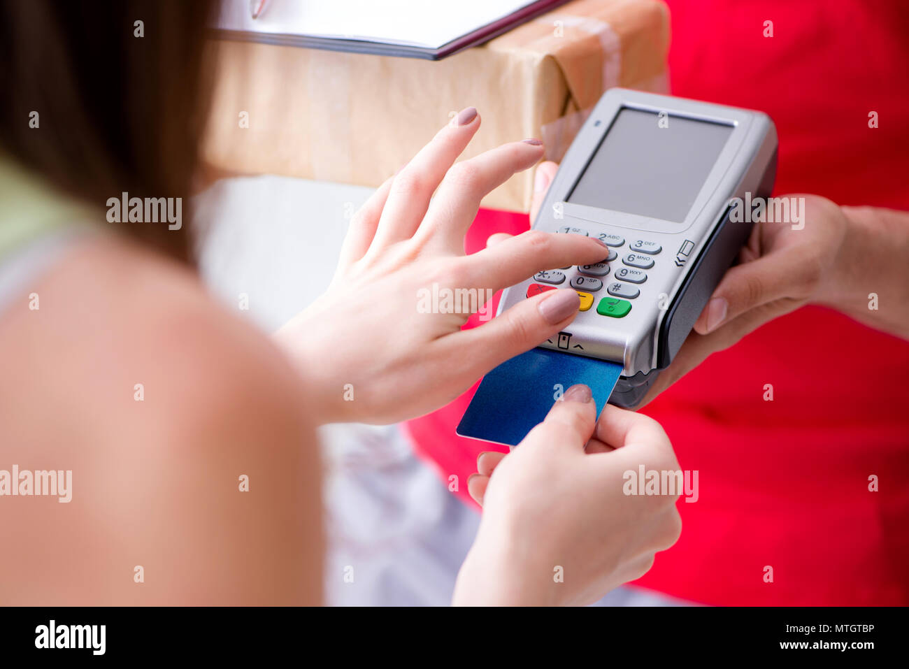 La consegna di pacchi essendo pagato con pos e carta di credito Foto Stock