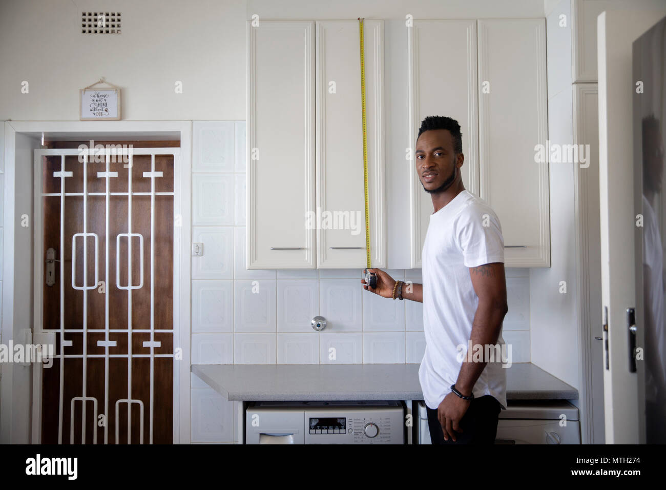 L'uomo la misurazione mobile da cucina Foto Stock