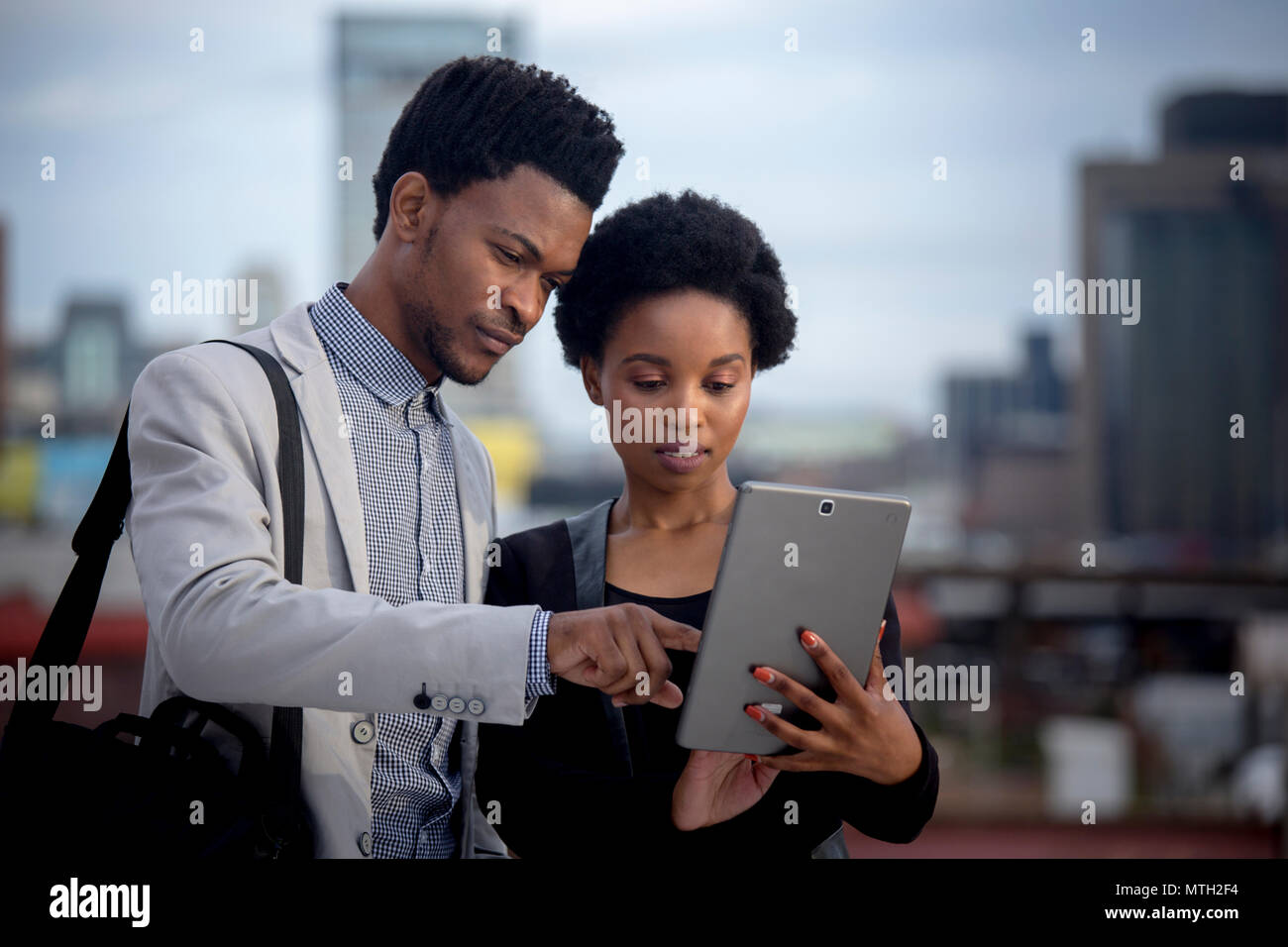 Business uomo e donna che guarda la compressa Foto Stock