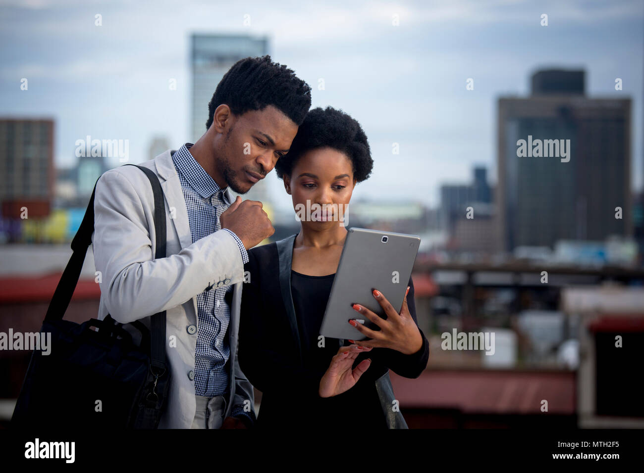 Business uomo e donna che guarda la compressa Foto Stock