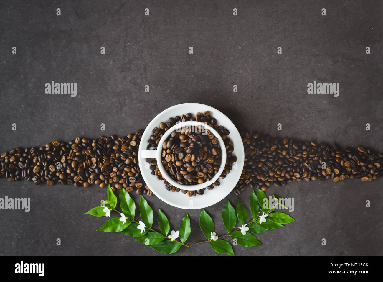 Tazza di caffè e fagioli sul vecchio tavolo da cucina. Vista da sopra con copyspace per il testo Foto Stock