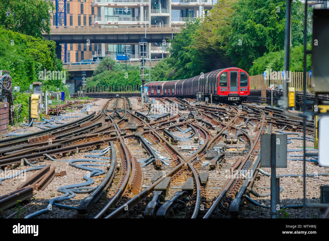 Un treno parte dalla città bianca della Metropolitana di Londra la navigazione di un array di punti e linee. Foto Stock