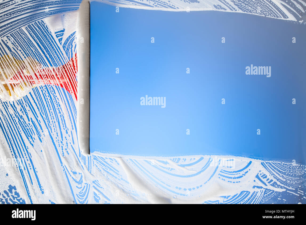La finestra di pulizia con spatola cielo blu Foto Stock