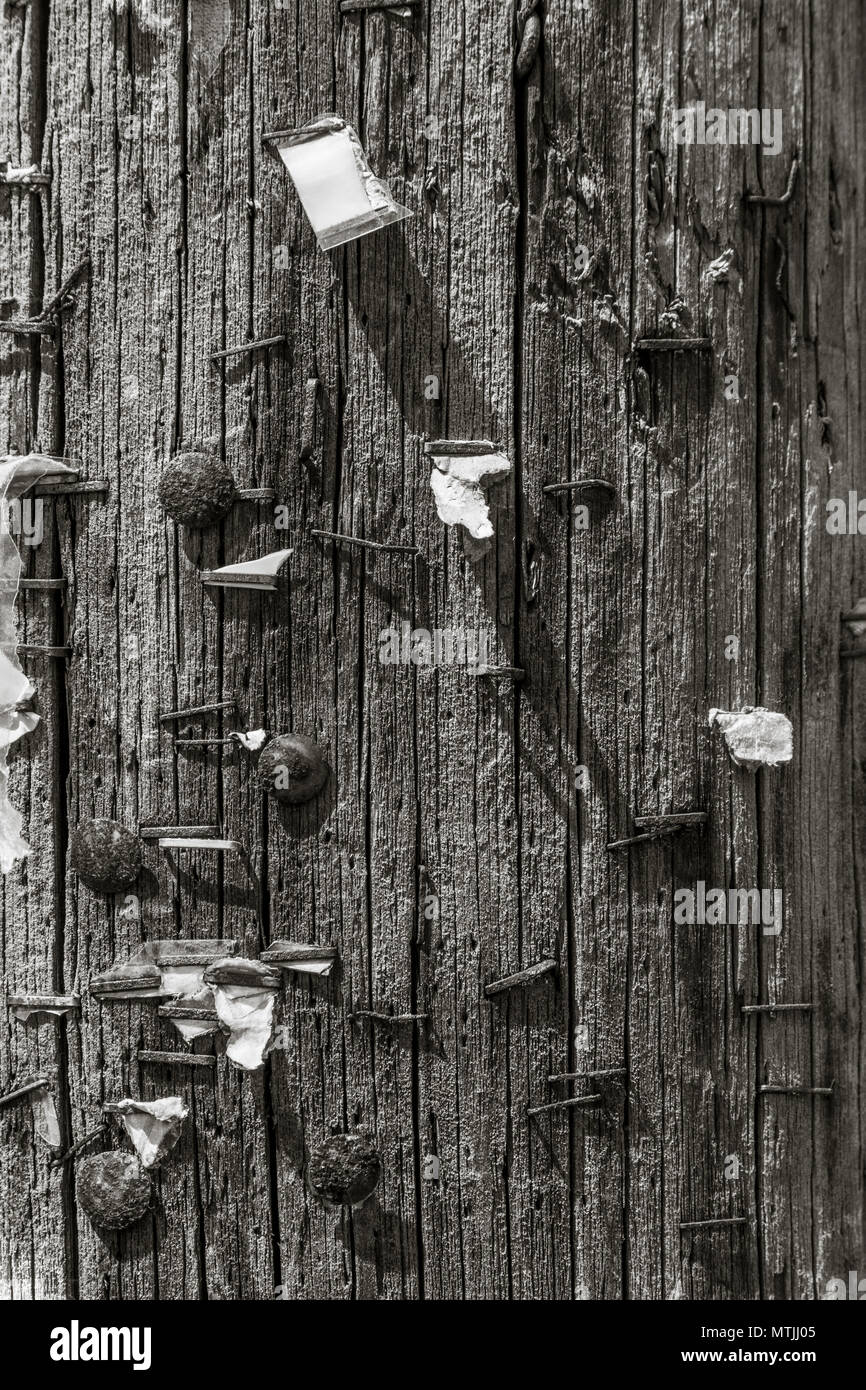 Monocromatico bacheca in legno con la formazione di ruggine vecchi punti metallici e rusty puntine da disegno - metafora per i messaggi persi, messaggio PIN qui, deserte comunità. Foto Stock