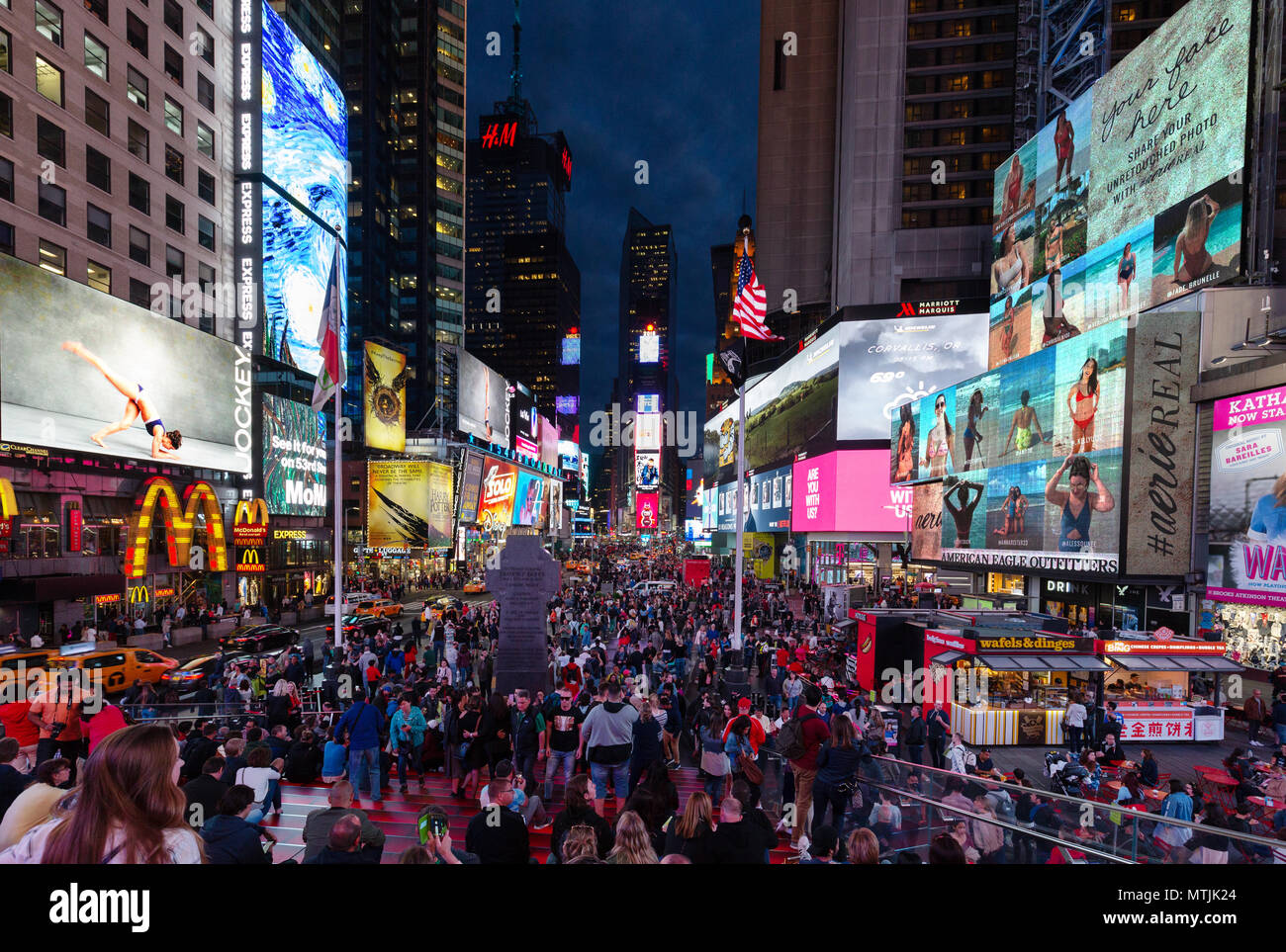 Times Square New York di notte, con la folla di gente e di luci al neon colorate di segni; Times Square e Midtown, New York City, Stati Uniti d'America Foto Stock