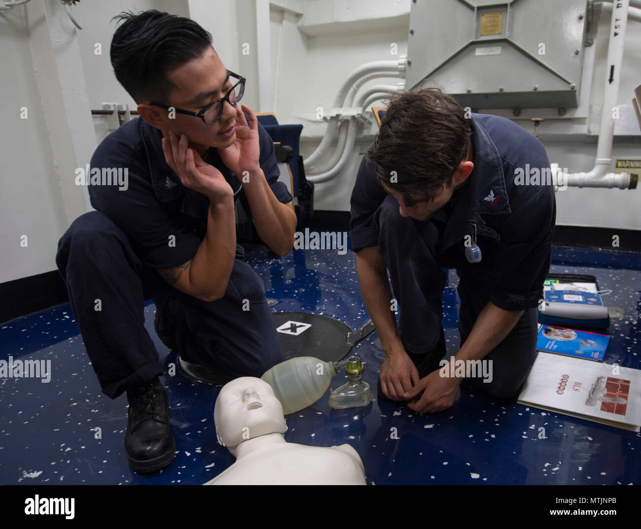 170102-N-KB426-070 sul Mare del Sud della Cina (GEN. 2, 2017) Ospedale Corpsman 3rd Class Justin A. Lam, sinistra, insegna Fire Controlman 2a classe Christopher M. Conley come eseguire cardio-rianimazione polmonare (CPR) durante una certificazione CPR Classe a bordo della Arleigh Burke-class guidato-missile destroyer USS John S. McCain (DDG 56). La nave è di pattuglia nel Mare della Cina del Sud il supporto di sicurezza e stabilità nella Indo-Asia-regione del Pacifico. (U.S. Foto di Marina di Massa lo specialista di comunicazione di terza classe James Vazquez/rilasciato) Foto Stock