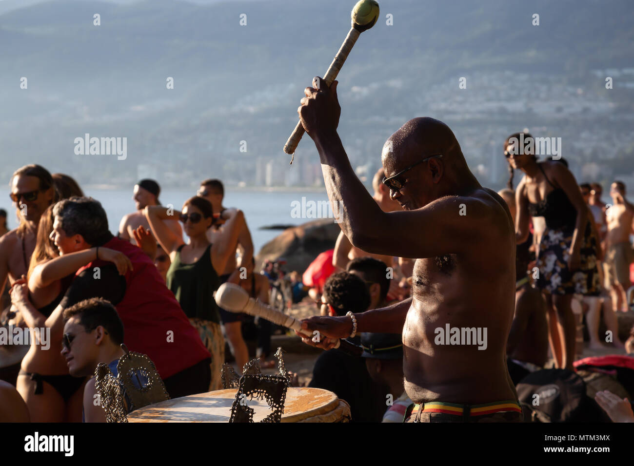 Terza Spiaggia, il centro cittadino di Vancouver, British Columbia, Canada - 22 Maggio 2018: Persone aventi il divertimento a un cerchio del tamburo evento durante una vibrante del tramonto. Foto Stock