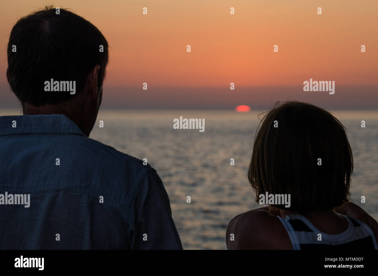 Coppia matura godere la calma tramonto sull'oceano. Libertà di sognare il futuro di pensionamento. Foto Stock