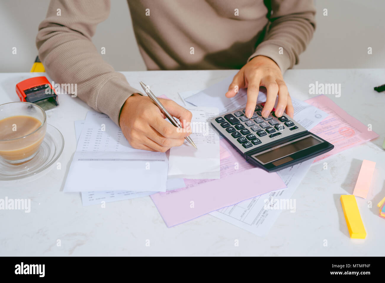Man mano facendo finanze e calcolare sulla scrivania su costo presso l'ufficio domestico. Foto Stock