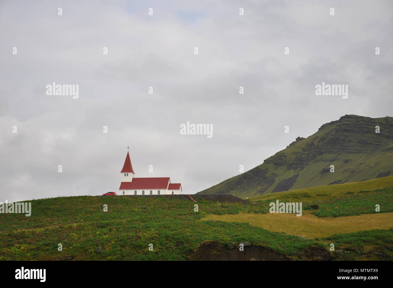 Vik mi Myrdal chiesa sulla collina di erba, Islanda Foto Stock