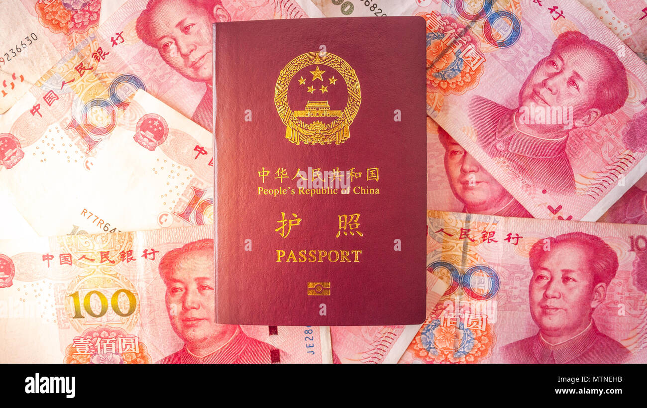 Passaporto cinese posto su alcuni 100 yuan cinese note. Il documento di viaggio per i cittadini nel territorio continentale della Repubblica popolare cinese Foto Stock