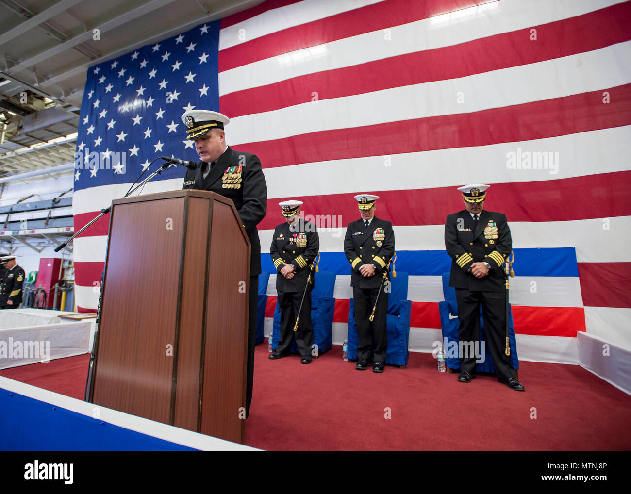 170109-N-TH560-415 Sasebo, Giappone (GEN. 9, 2017) della Cmdr. Prezzo Curtis, cappellano del comando di assalto anfibio nave USS Bonhomme Richard (LHD 6) eroga la benedizione eucaristica durante un squadrone anfibio (PHIBRON) 11 Modifica del comando cerimonia. Bonhomme Richard, distribuita a Sasebo, Giappone, serve in avanti per fornire una rapida capacità di risposta in caso di emergenza regionale o calamità naturali. (U.S. Foto di Marina di Massa lo specialista di comunicazione di terza classe Jeanette Mullinax/rilasciato) Foto Stock