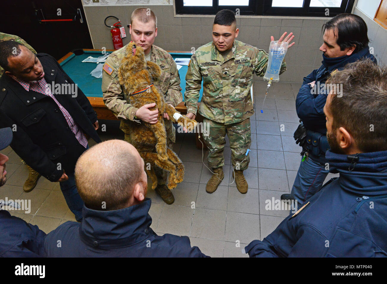 Stati Uniti Army Spc. Jose Armendariz assegnata alla sanità pubblica attività Italia, spiega come effettuare un esame medico su un peluche cane alla polizia italiana Squadra Cinofili K9 aeroporto di Venezia e la Questura di Padova e U.S. Air Force a Caserma Ederle, Vicenza, Italia, Gennaio 17, 2017. Militari di cane da lavoro le squadre sono utilizzati in pattuglia, farmaco e rilevamento esplosivi e specializzato funzioni di missione per il Dipartimento della difesa e di altre agenzie governative. Il militare 525th cane da lavoro di distacco, la formazione congiunta con la polizia italiana Squadra Cinofili K9 aeroporto di Venezia e la Questura di Padova Foto Stock