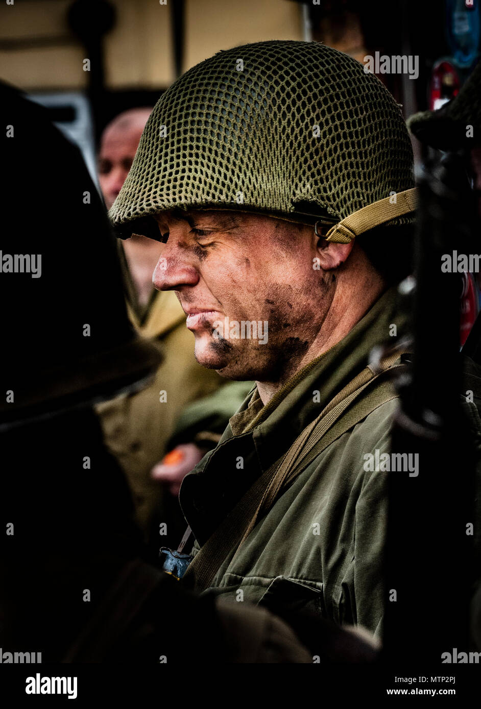 Ritratto di un soldato americano soldato dalla Seconda guerra mondiale con una faccia sporca che indossa un casco americano (poste da attore) Foto Stock