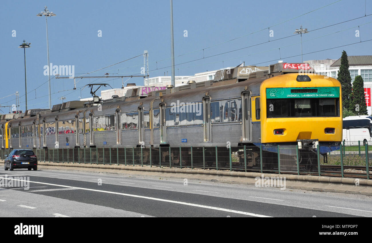 L'UEM treni passeggeri in esecuzione tra i due viali di strada a Belem vicino a Lisbona, Portogallo Foto Stock