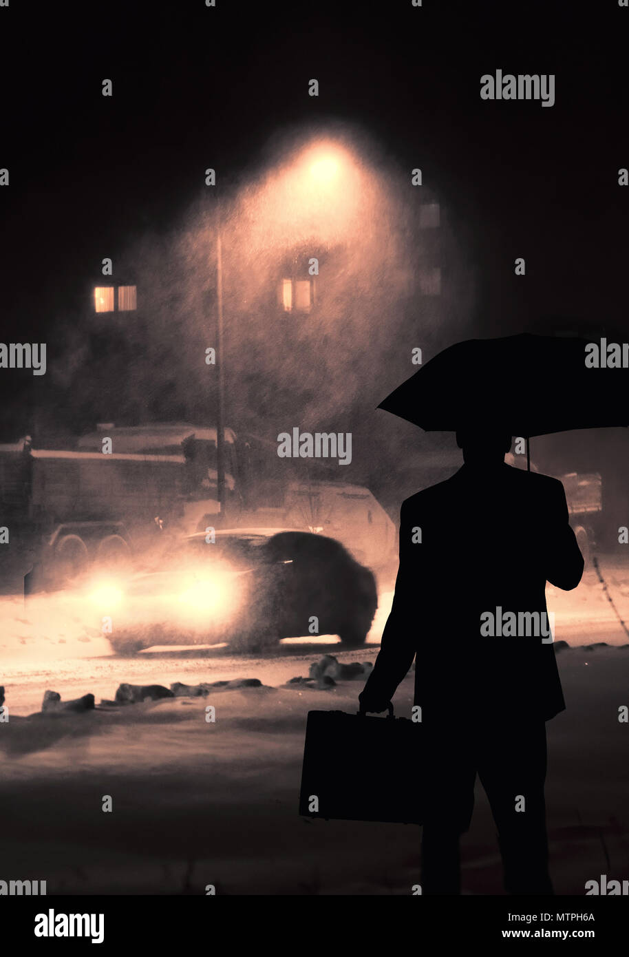 Silhouette di un uomo con una valigetta in attesa con un ombrello in una fredda notte nevosa Foto Stock