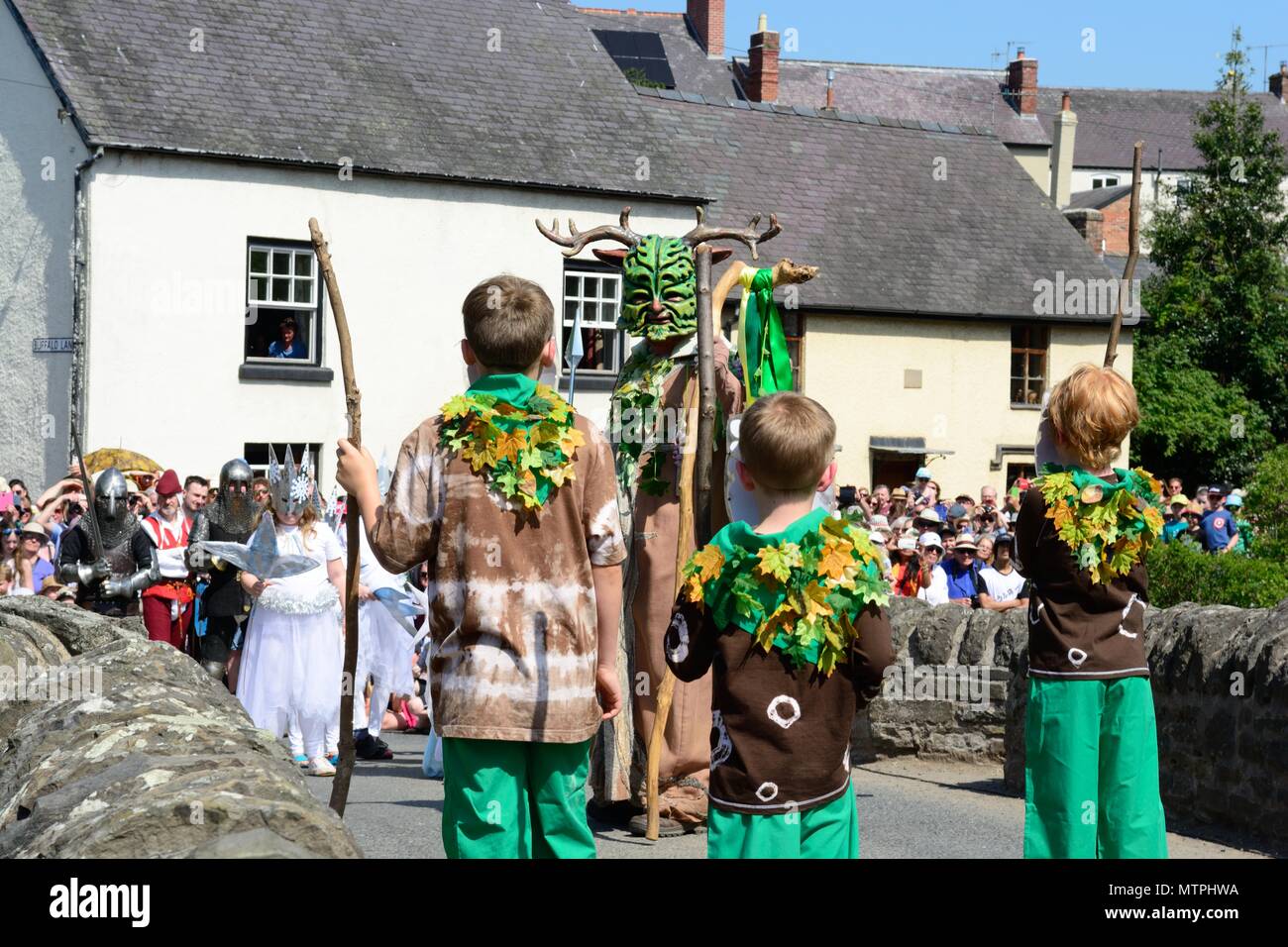 Vittoria per il Green Man di Clun sul ghiaccio regina in una battaglia per bandire l'inverno e estate di ripristino sul ponte medievale nel maggio Shropshire England Regno Unito Foto Stock