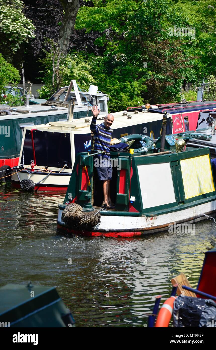 Un uomo sventolare da un battello del canale sul Regents Canal in Little Venice, Londra, Inghilterra Foto Stock