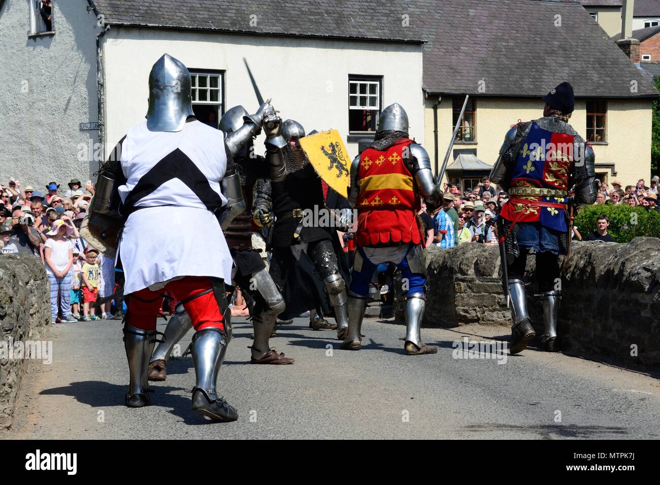 Battaglia tra i soldati medievali della regina di ghiaccio e il verde di uomo di Clun sul ponte Clun Shropshire England Regno Unito Foto Stock