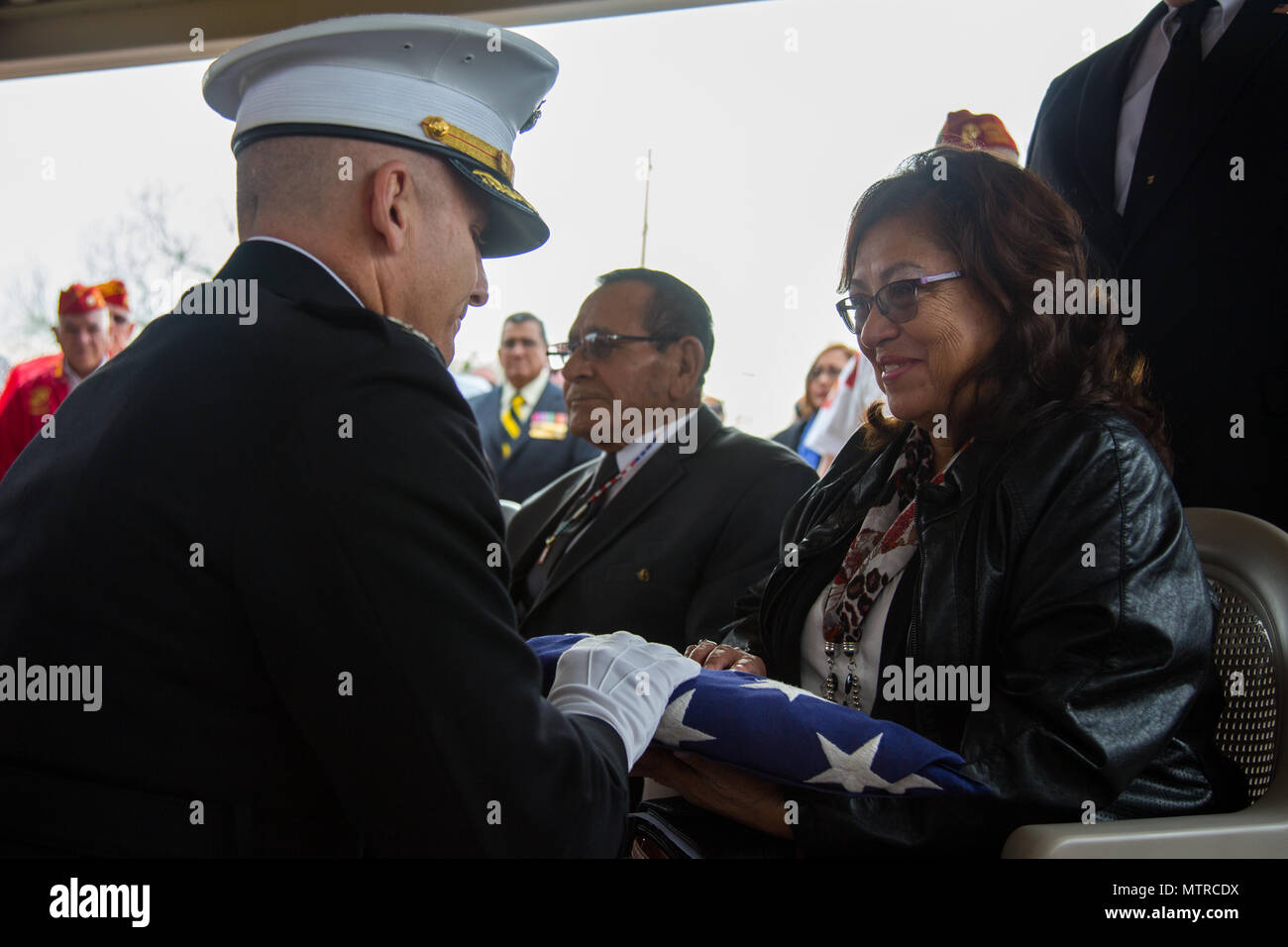 Stati Uniti Marine Corps Col. Steven Weintraub presenta un flag di Pilar Jiminez, in onore di suo fratello, 1969 Congressional Medal of Honor destinatario U.S. Marine Corps Lance Cpl. José Francisco Jimenez, durante il confino di Jimenez a Phoenix il Jan 17, 2017. Jimenez, originariamente un nativo del Messico, si trasferì con la famiglia a Red Rock, Ariz. quando aveva dieci anni. Jimenez andò a unirsi al Marine Corps dopo la laurea di alta scuola in 1968, prima per poi essere spediti alla Repubblica socialista del Vietnam nel febbraio del 1969. In Agosto di 1969, Jimenez è stato ucciso in azione su postumo ricevendo th Foto Stock