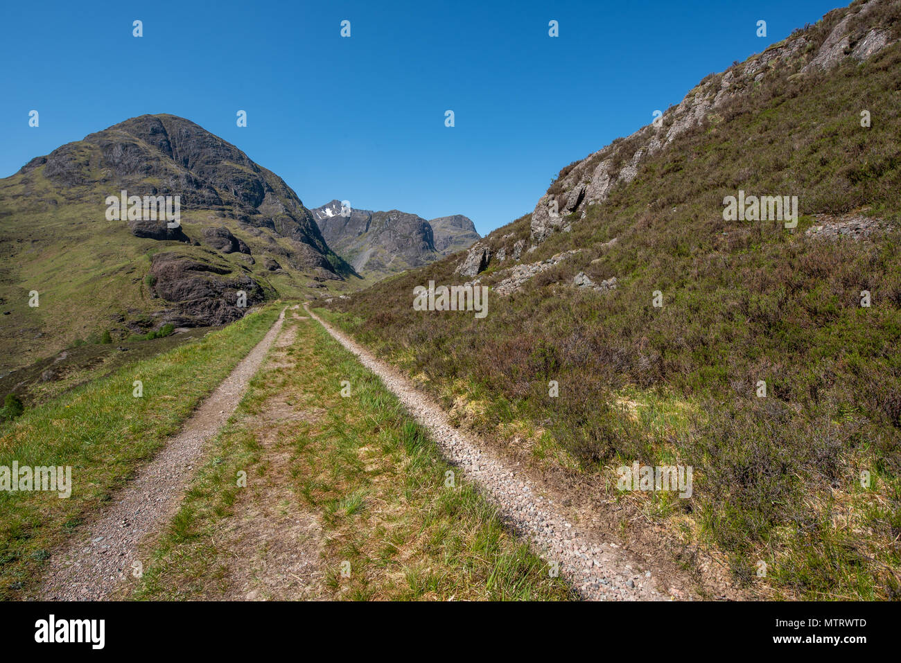 La vecchia strada militare sulle colline sopra la nuova strada che corre attraverso Glencoe con la struttura ad albero delle sorelle in background Foto Stock