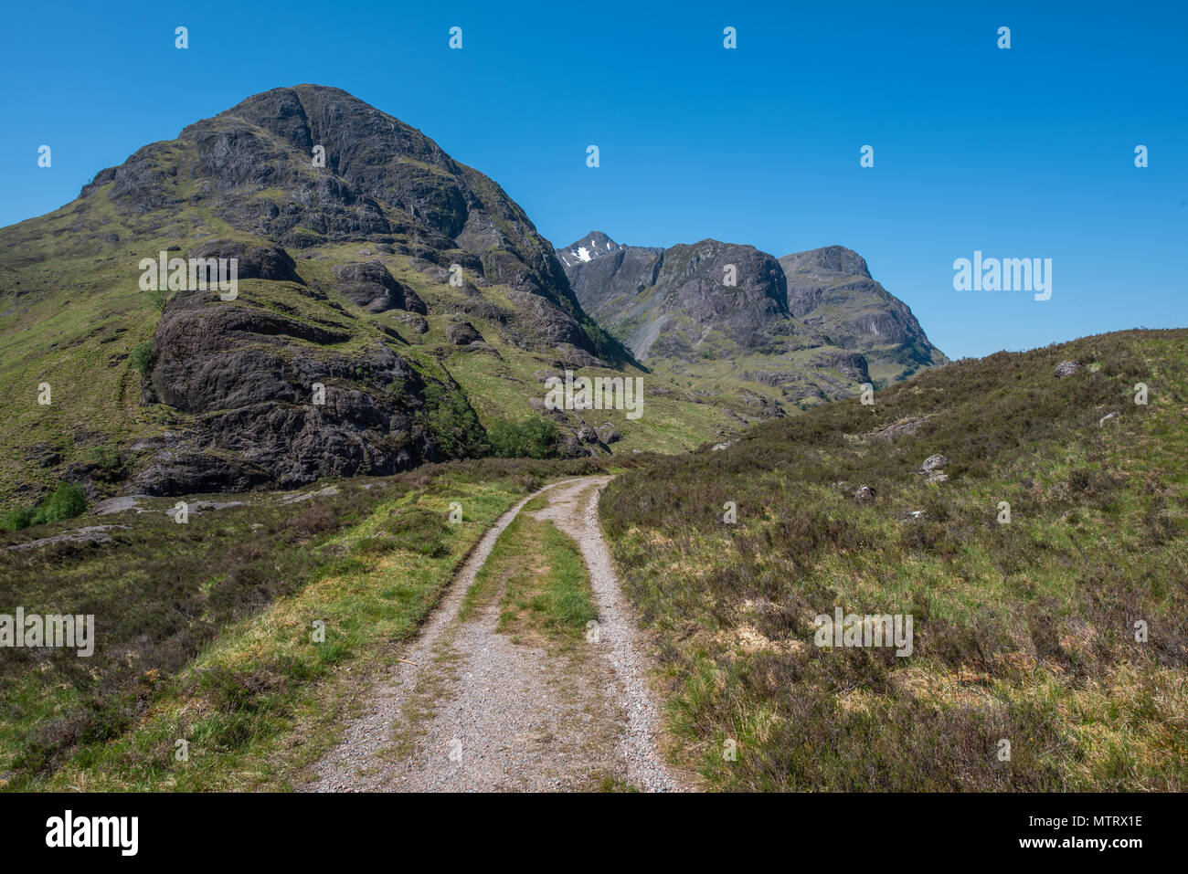 La vecchia strada militare sulle colline sopra la nuova strada che corre attraverso Glencoe con la struttura ad albero delle sorelle in background Foto Stock