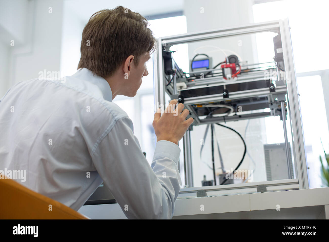Piacevole giovane intern learning stampanti 3D Algoritmo di lavoro Foto Stock