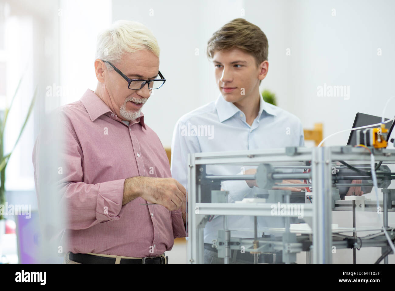 Ingegnere Senior mostra intern come esaminare stampante 3D Foto Stock