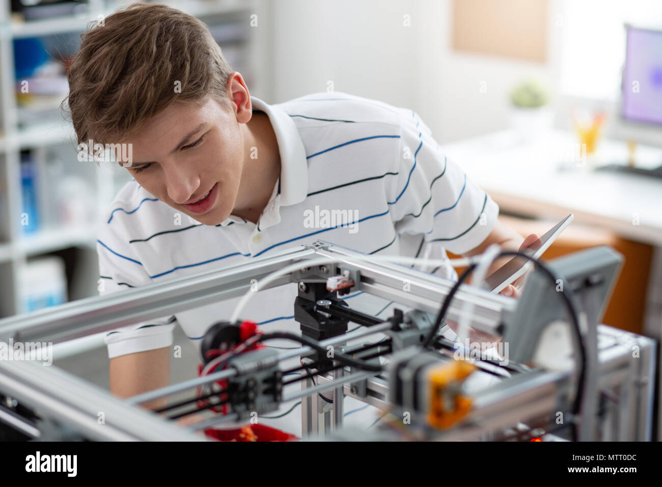 Upbeat giovane ingegnere la stampa 3D il peperone Foto Stock