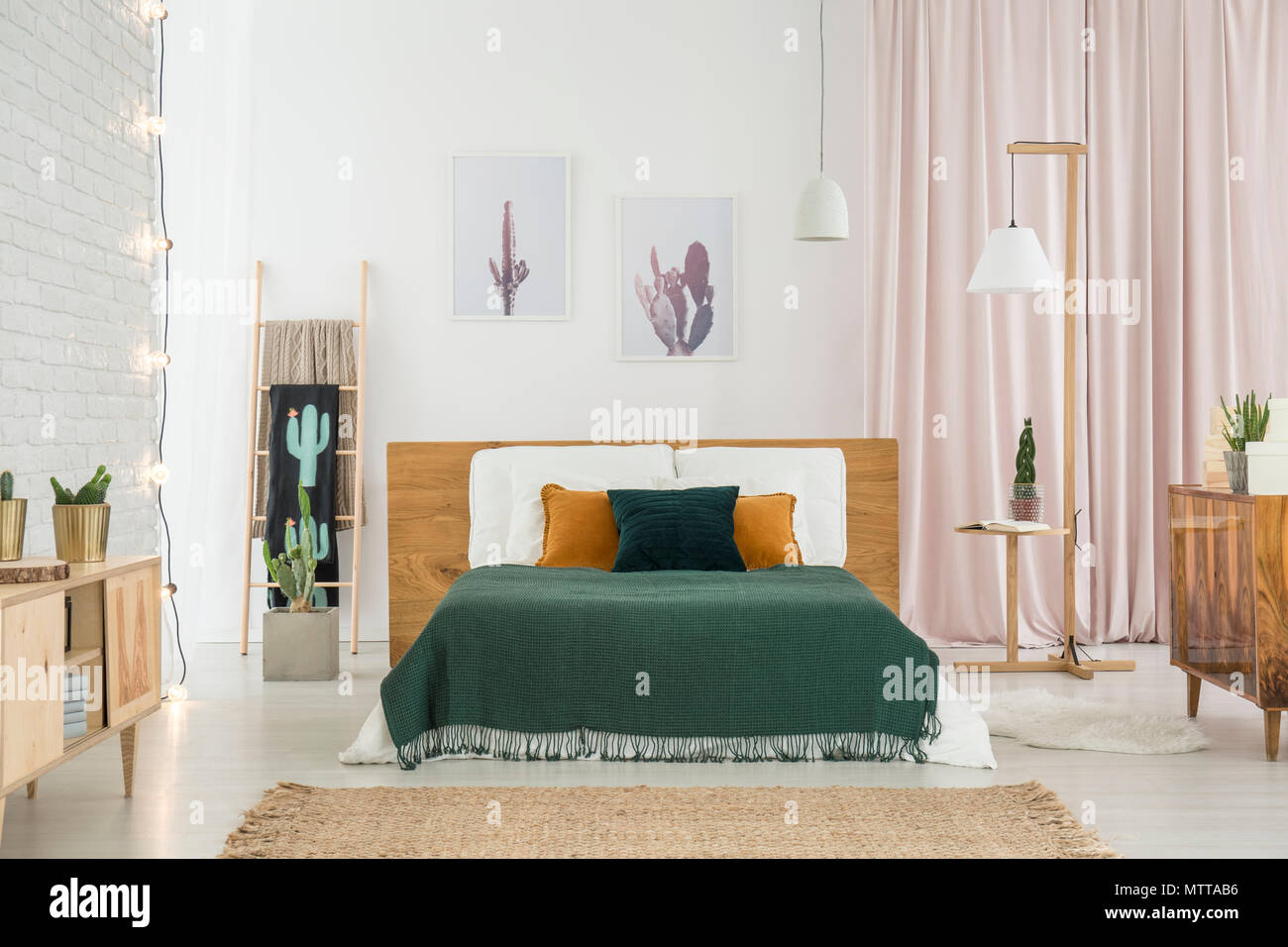 Dark coperte e cuscini sul letto king size nella camera da letto in stile  rustico interno con lampada, cactus e mobili in legno Foto stock - Alamy