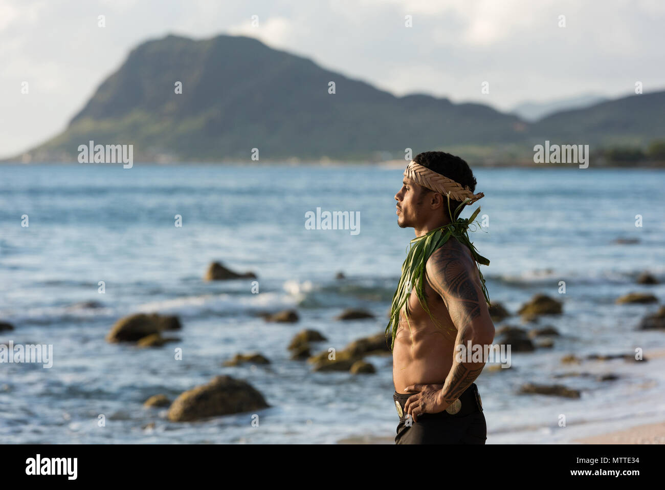 Maschio ballerino di fuoco in piedi con le mani sui hip presso la spiaggia Foto Stock