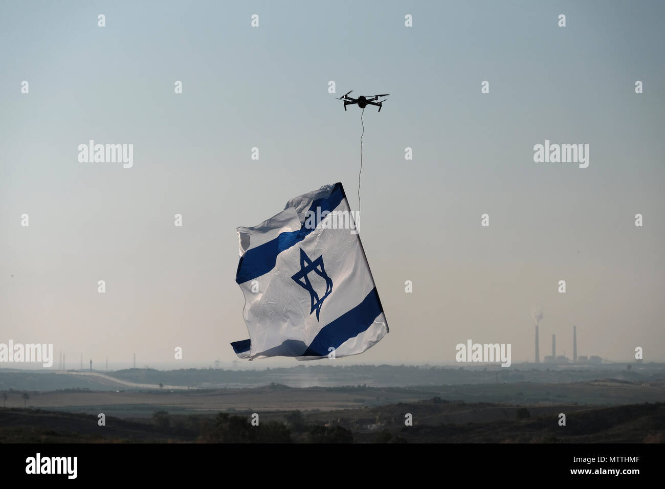 Un drone volato da un uomo israeliano porta la bandiera nazionale di  Israele vicino alla recinzione di confine con la striscia di Gaza sud  Israele Foto stock - Alamy