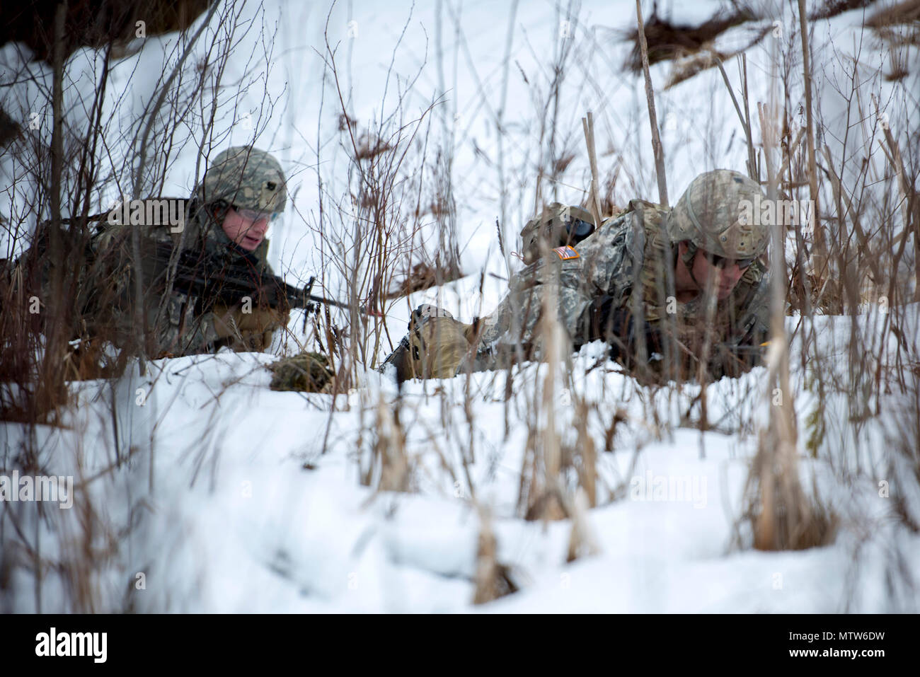 Stati Uniti Army Spc. Forrest Watkins, sinistra e Staff Sgt. Steven Hernandez, entrambi assegnati alla società alfa, 3° Battaglione, 172nd Reggimento di Fanteria, 86a brigata di fanteria combattere Team (montagna), Vermont Guardia nazionale, alta strisciare verso il loro obiettivo, a Camp Ethan Allen Sito di formazione, Gerico, Vt., 23 gennaio 2017. I soldati eseguita squad imboscata esercizi come parte del loro inverno formazione annuale. (U.S. Air National Guard foto di Tech. Sgt. Sarah Mattison) Foto Stock