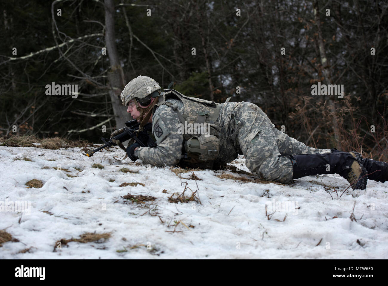Un soldato assegnato alla società alfa, 3° Battaglione, 172nd Reggimento di Fanteria, 86a brigata di fanteria combattere Team (montagna), Vermont Guardia nazionale, alta strisciare verso il loro obiettivo, a Camp Ethan Allen Sito di formazione, Gerico, Vt., 23 gennaio 2017. I soldati eseguita squad imboscata esercizi come parte del loro inverno formazione annuale. (U.S. Air National Guard foto di Tech. Sgt. Sarah Mattison) Foto Stock