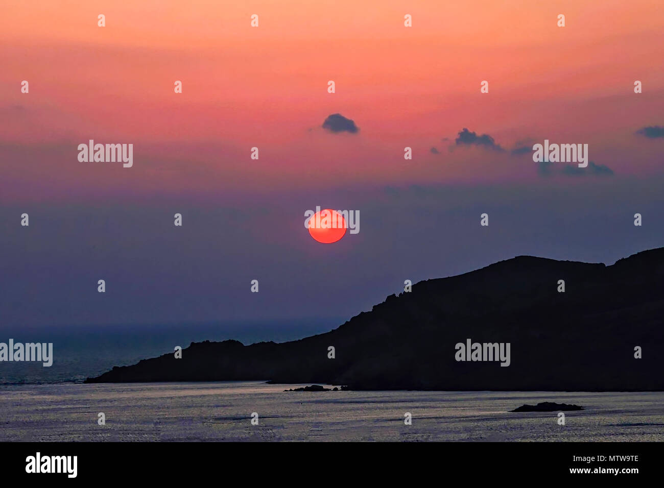 Red Sun. spettacolare idilliaco seascape tramonto in Finikas Bay in Syros Island, Grecia. Immagine di stock. Foto Stock