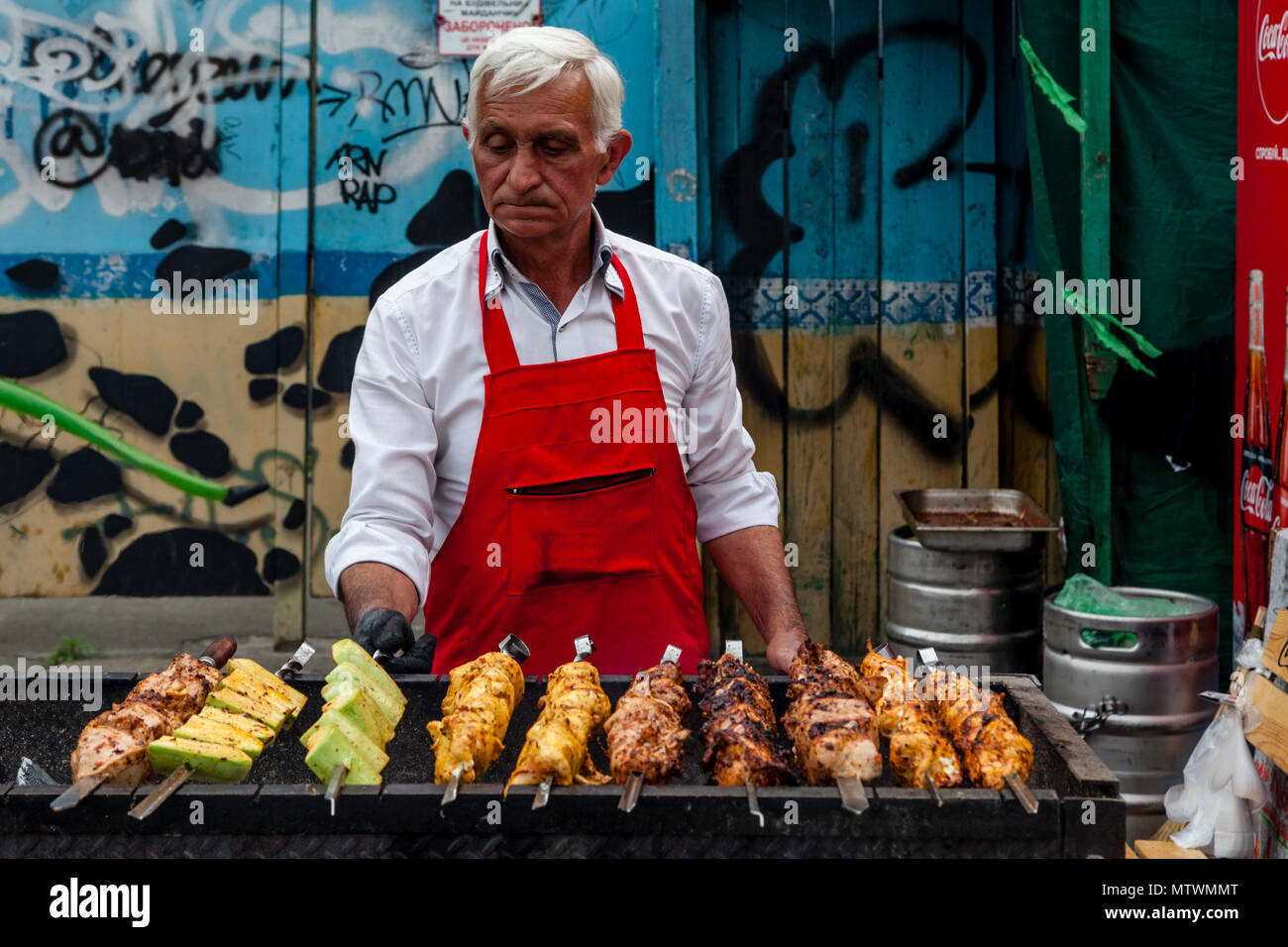 Un uomo di cottura degli alimenti in strada, Kiev, Ucraina Foto Stock