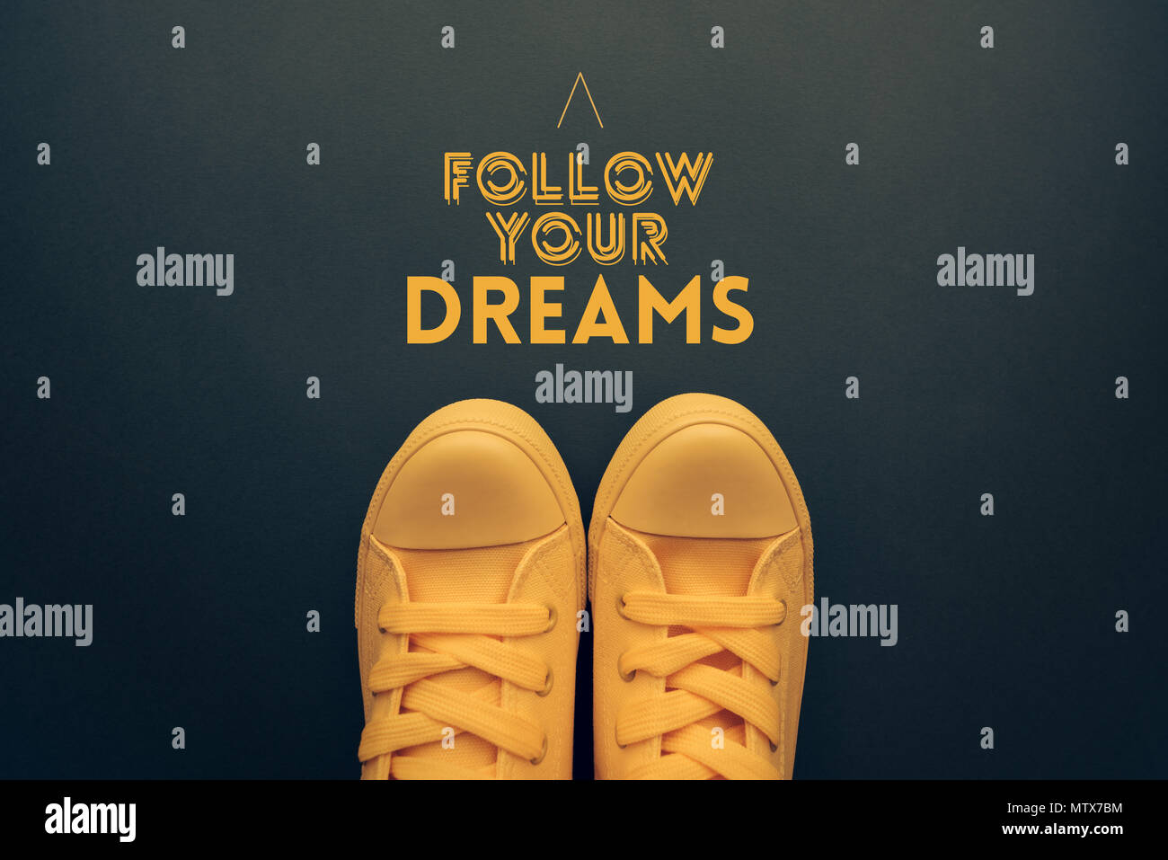 Seguire i vostri sogni preventivo motivazionale, giovane in Giallo casual scarpe in tela in piedi sopra il testo Foto Stock