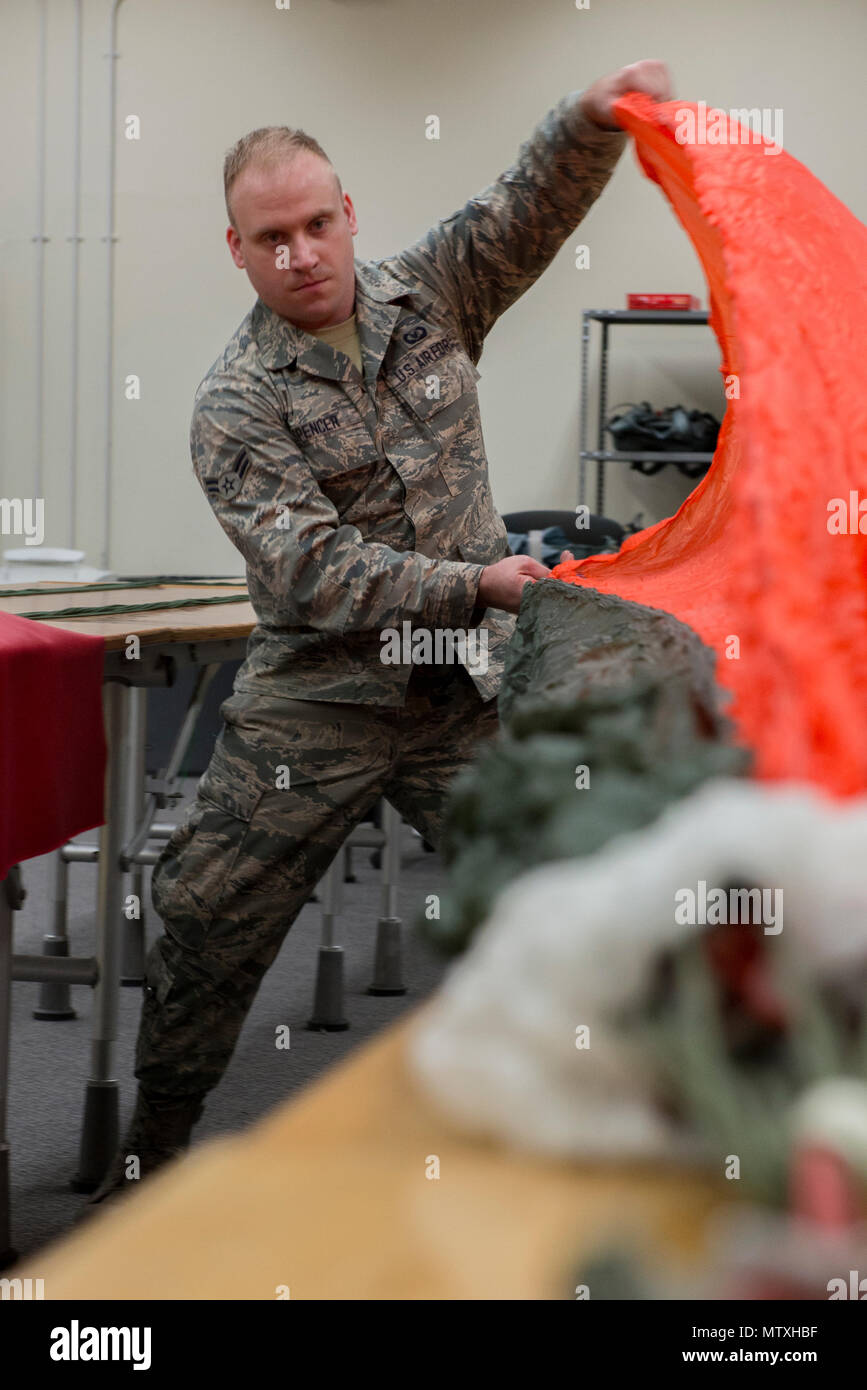 Airman 1. Classe Brent T. Spencer, 374 Operations Support Squadron equipaggi di volo volo apparecchiature apprendista, pre-pack di un paracadute tettoia gen. 31, 2017 a Yokota Air Base, Giappone. Il volo AFE è responsabile per la riparazione, imballaggio, e tutto intorno la manutenzione dei paracadute utilizzati da equipaggi e sopravvivenza, evasione, la resistenza e la fuga degli specialisti. (U.S. Air Force foto di Airman 1. Classe Donald Hudson) Foto Stock