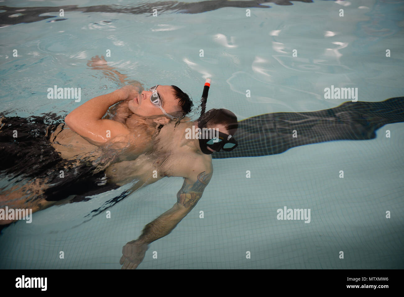 Petty Officer 2a classe Paolo Mills, un aviazione tecnico di sopravvivenza, treni in piscina presso il Massachusetts Maritime Academy su Cape Cod in Massachusetts il Gen 19, 2017. Questa tecnica di salvataggio è che cosa i nuotatori di salvataggio utilizzare quando portando i sopravvissuti al cestello per essere issata in attesa di MH-60 Jayhawk elicottero per portarli a casa in modo sicuro. (U.S. Coast Guard foto di Sottufficiali di terza classe Nicole J. Groll) Foto Stock