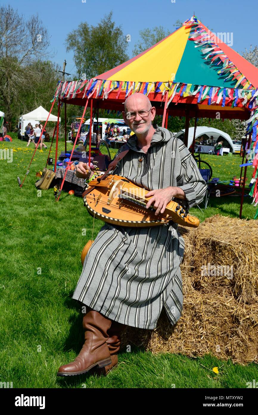 Uomo vestito in costume tradizionale giocando la Ghironda Clun al Green man Festival Shropshire Inghilterra Foto Stock