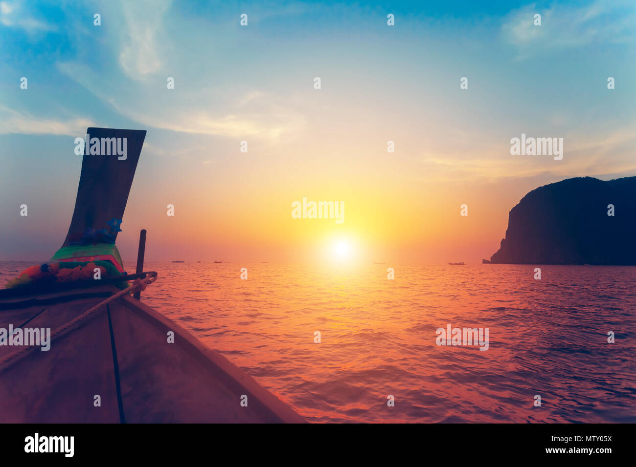 Chiudere l immagine della prua della pesca tradizionale barca di legno. Splendida colorato tramonto sull'oceano e la roccia calcarea accanto alle esotiche Isole Phi Phi, il Regno di Thailandia. Foto Stock