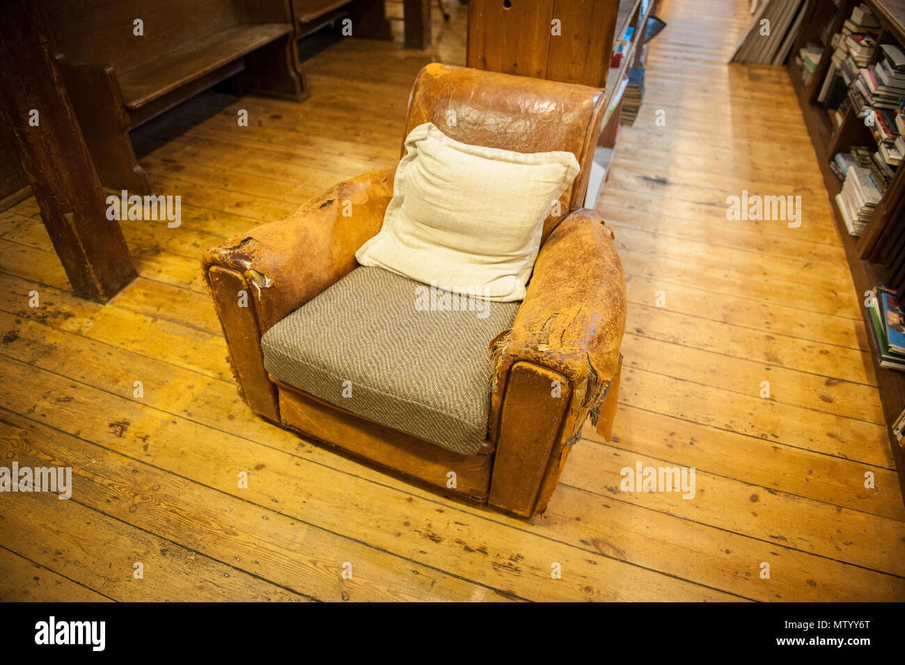 Bistrattato poltrona in pelle in Richard Booth's Cinema Bookshop in Lion Street Hay-on-Wye Foto Stock