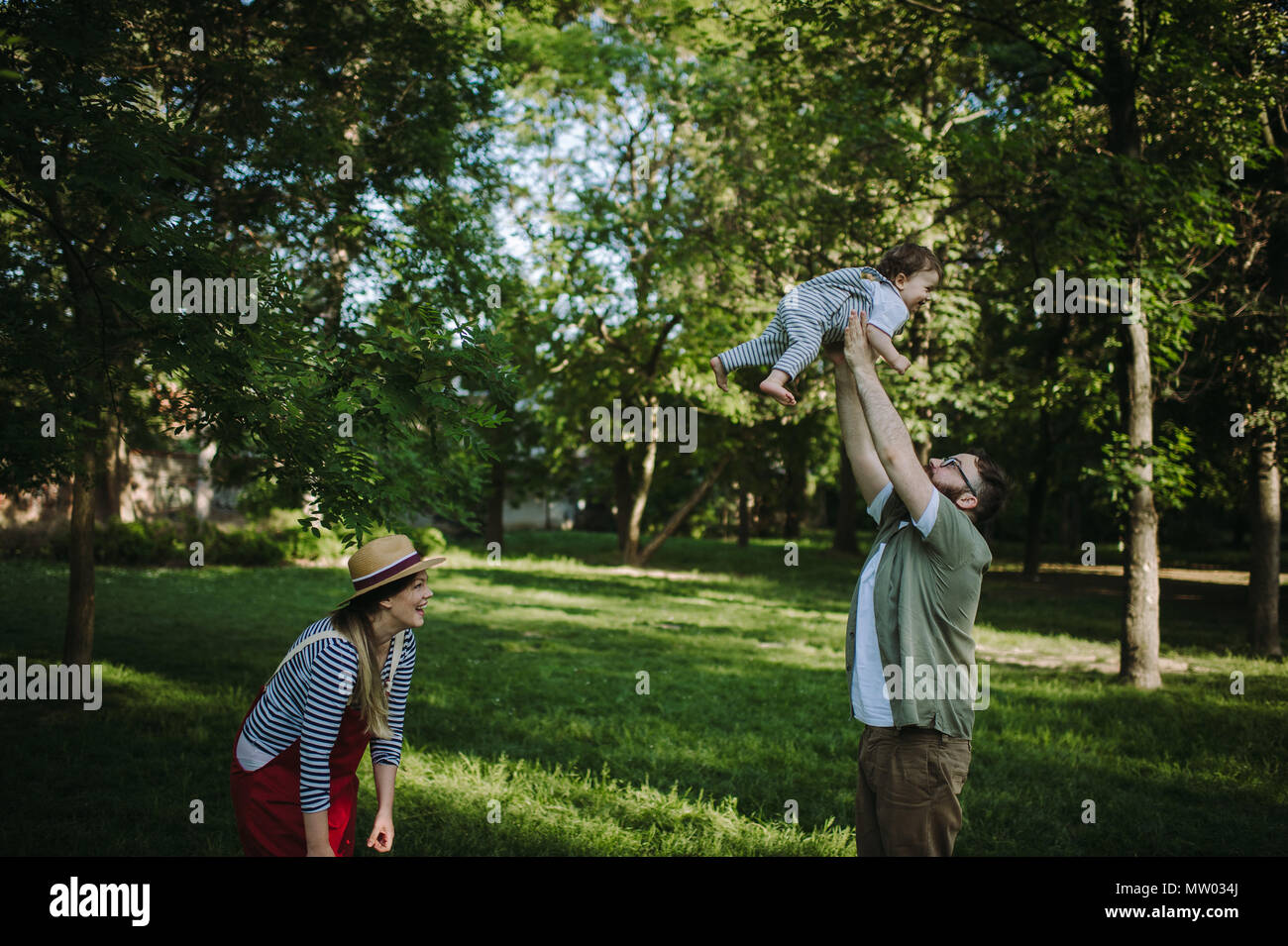 Il padre e la madre a giocare con il loro figlio nel parco Foto Stock